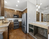 Modern kitchen with granite countertops, ample storage, and stainless-steel appliances.