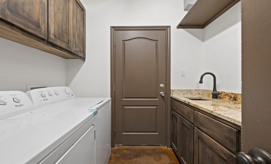 The laundry room is equipped with built-in storage and a utility sink, providing convenience and organization for all your laundry needs.