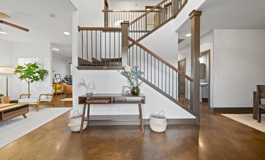 Step into the entryway featuring a soaring ceiling and grand staircase, making a stunning first impression.