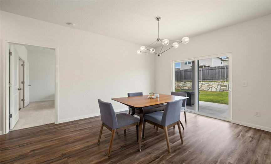 Gather with loved ones in the inviting dining area, featuring sliding glass doors that lead to the covered back patio, seamlessly blending indoor and outdoor living.