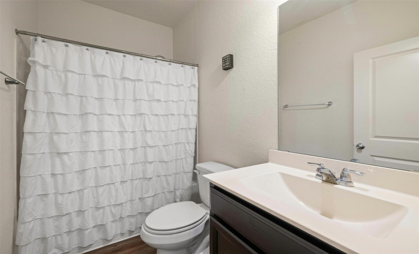 Appreciate the shared guest bath servicing the secondary bedrooms, featuring modern fixtures and ample counter space.