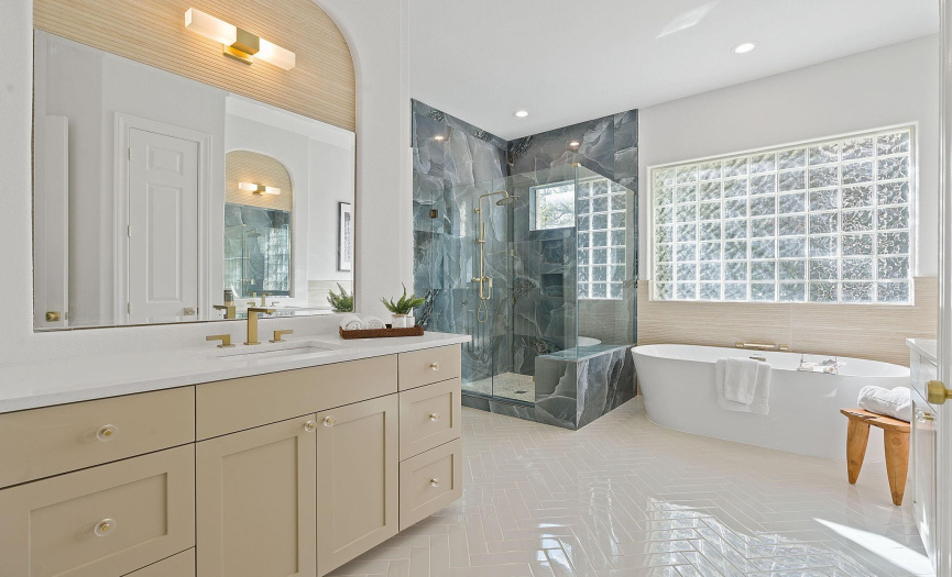Stunning primary bathroom with a separate shower and tub.  Separate vanities and new tile everywhere.
