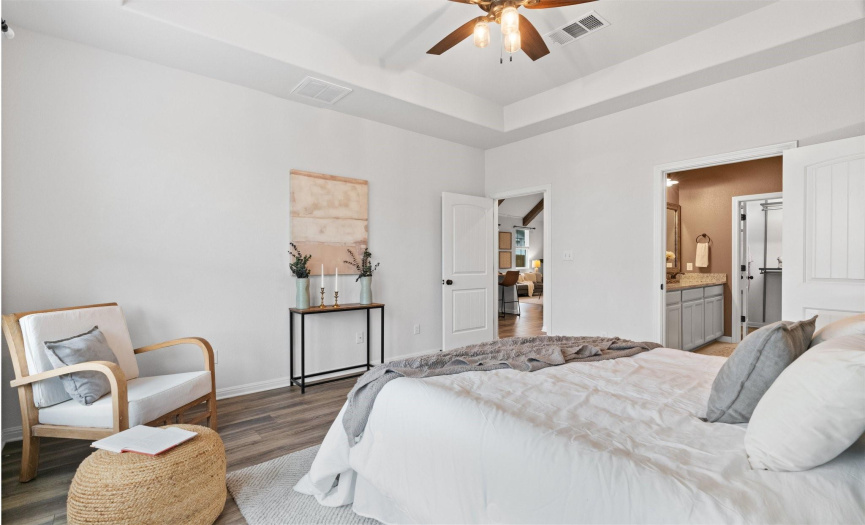 Retreat to the tranquil haven of the primary bedroom, where neutral tones and high ceilings create a soothing atmosphere for rest and rejuvenation.