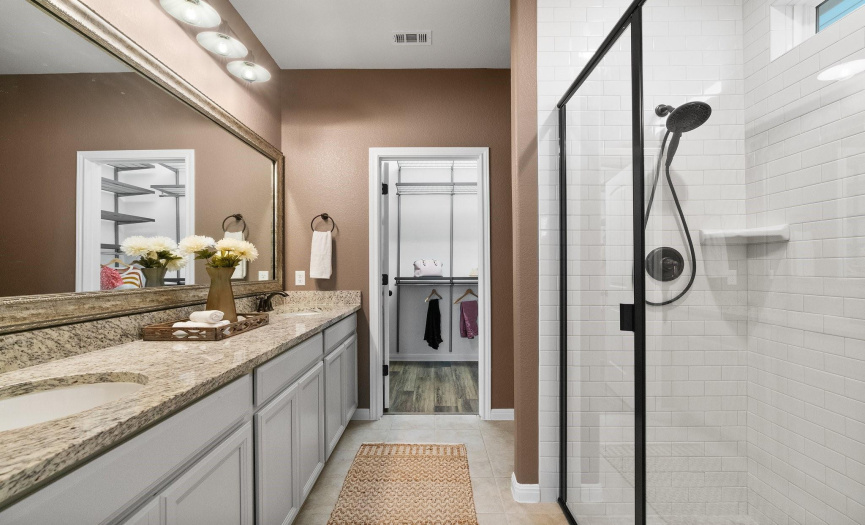 Luxuriate in the spa-like ambiance of the primary bathroom, boasting a granite dual vanity and oversized walk-in shower for ultimate relaxation.