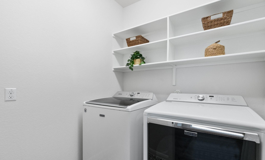 Streamline your chores in the full-size laundry room, equipped with built-in shelving and ample space for efficient cleaning routines.