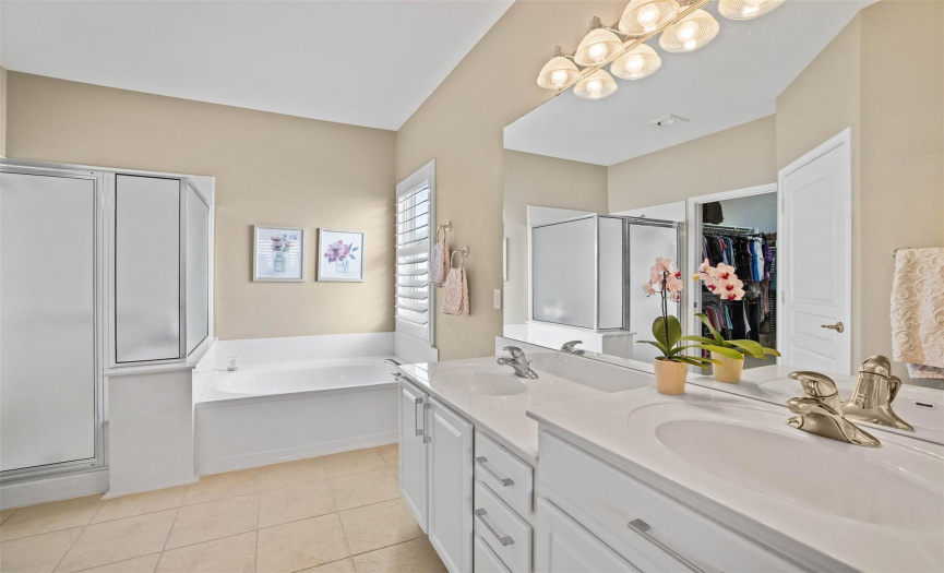 The ensuite bath offers a tiered double vanity, a relaxing soaking tub, and a separate walk-in shower.