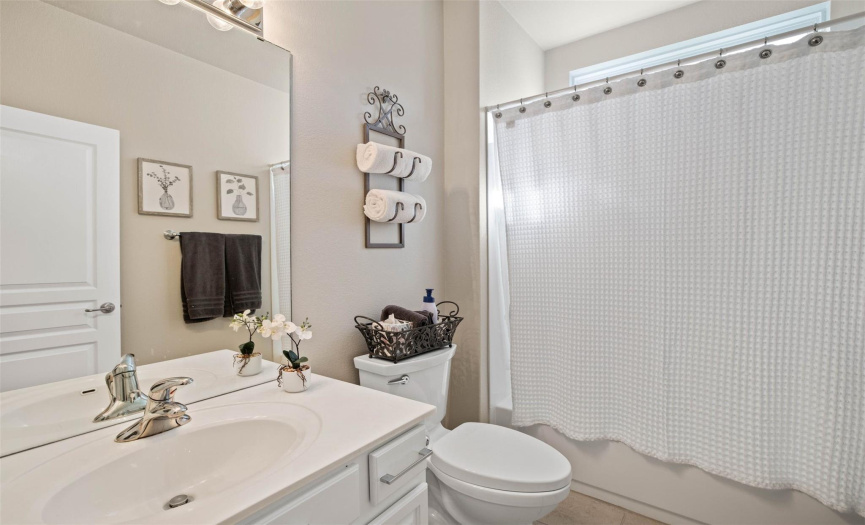The second full bath is well-appointed near the front of the home for both secondary bedrooms. 