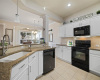 The kitchen features soft close white cabinetry with pull out drawers complemented by granite counters.