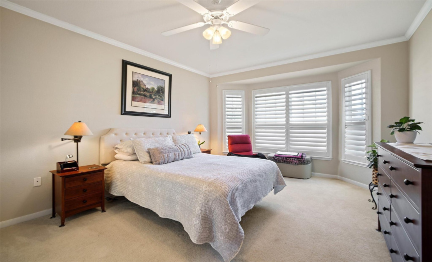Expansive windows in the primary suite offer natural light, while plantation shutters guarantee a private feel.