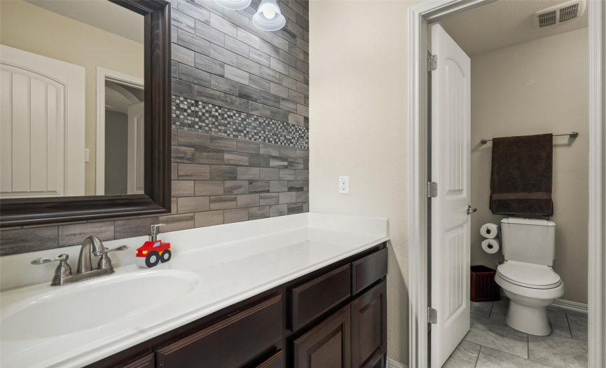 This third full secondary bathroom offers a convenient separate water closet with the shower/tub combo and commode.