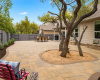 Amazing backyard for entertaining and relaxing with a covered back porch and a huge stone patio surrounded by mulched gardens and shade trees. 
