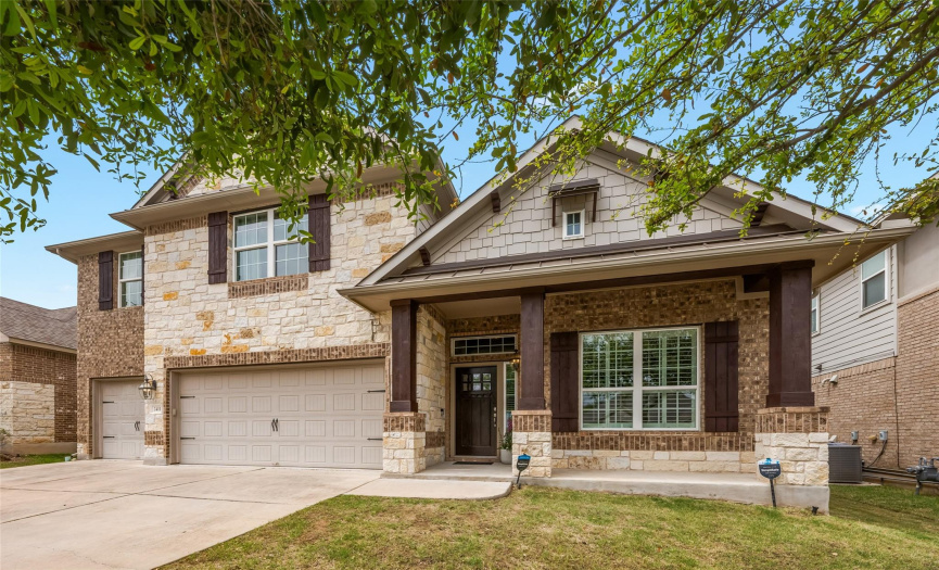 Beautiful curb appeal with striking brick & stone masonry, a welcoming front porch, and three car garage.