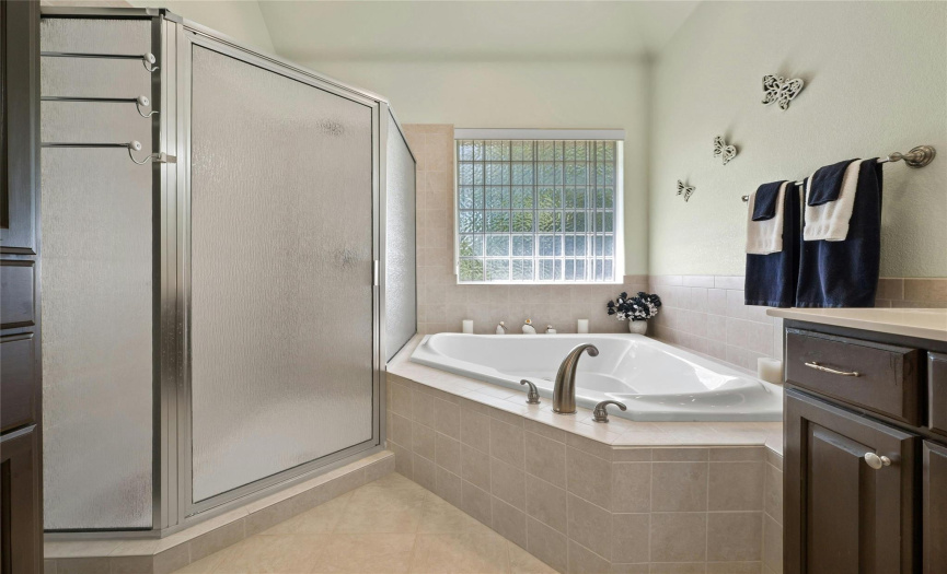 walk in shower and soaking tub in primary bathroom