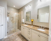 The primary bathroom has been tastefully remodeled, boasting an oversized shower, double vanity, and dual closets. 