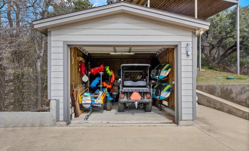 Garage with current water accessories and golf cart in it. This is a golf cart friendly community!