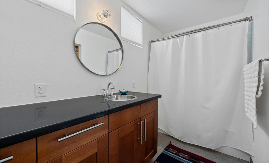 Primary suite vanity with updated fixtures and a tub/shower combo