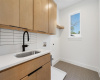 A convenient upstairs laundry room with a sink and storage