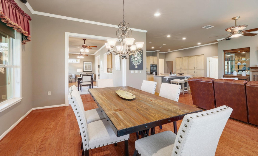 Elegance meets functionality in this dining space featuring crown molding, hardwood flooring, and plenty of room to accommodate guests.