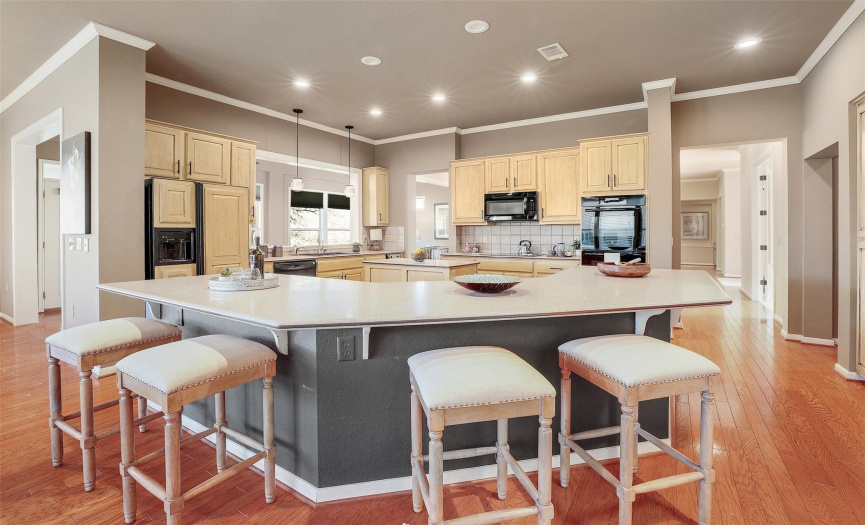 Step into the large and open kitchen, complete with a breakfast bar, abundant cabinetry, and quality appliances.