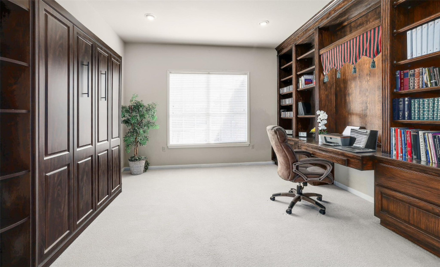 Discover versatility in the second bedroom, featuring custom built-ins that make it ideal for use as a home office or hobby room.