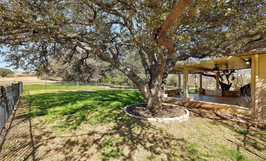 Step into the expansive backyard oasis, where lush landscaping and a fenced yard create a private retreat perfect for outdoor activities and relaxation.