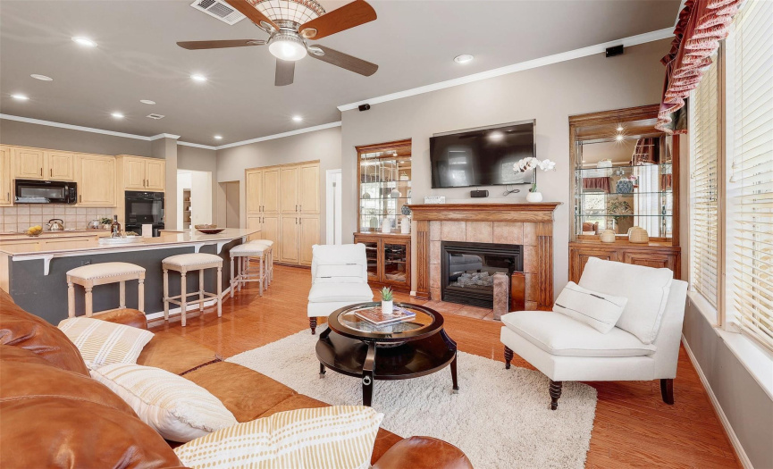 Relax in the inviting family room featuring hardwood flooring, crown molding, and a cozy wood-burning fireplace, perfect for cozy evenings with loved ones.