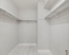 The remarkable walk-in closet adjacent to the primary bathroom exudes both luxury and functionality, offering ample space for meticulous organization and tidy storage.