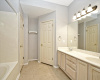 Primary bath with dual vanities, linen closet, and a private WC with door.  