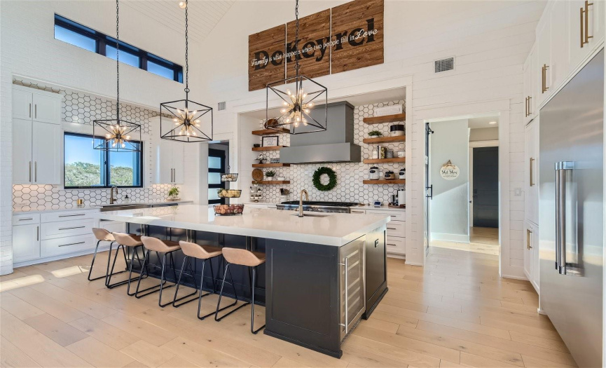 Indulge your culinary passions in the luxurious gourmet kitchen, boasting top-of-the-line Thermador appliances, a spacious built-in refrigerator, wine fridge, and a generous island complete with a convenient sink for effortless meal preparation and entertaining.