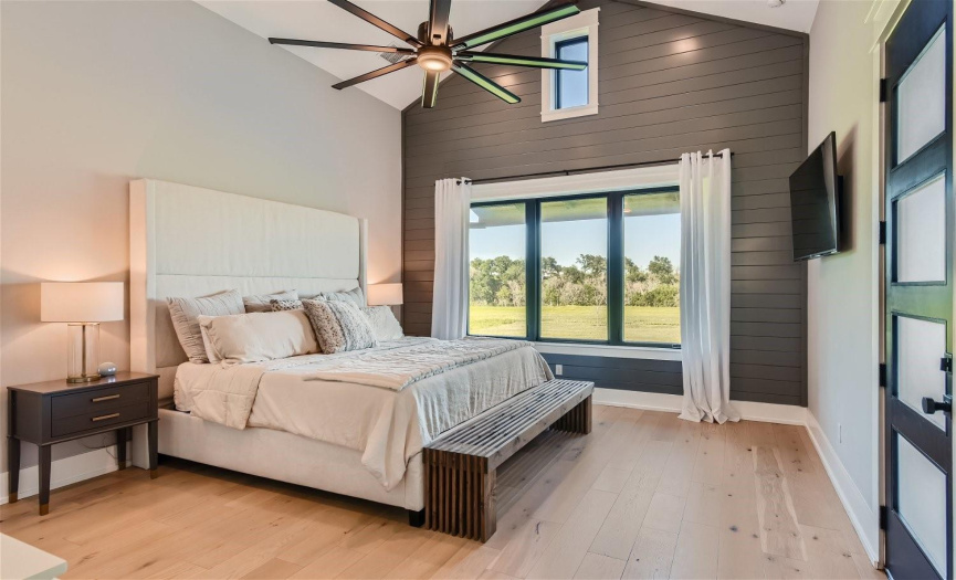 Enjoy serene views from the primary bedroom overlooking the expansive backyard, with a convenient door leading to the back patio for easy outdoor access.