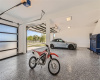 Extended three-car garage with finished flooring and glass doors, perfect for car enthusiasts or a cool workshop.