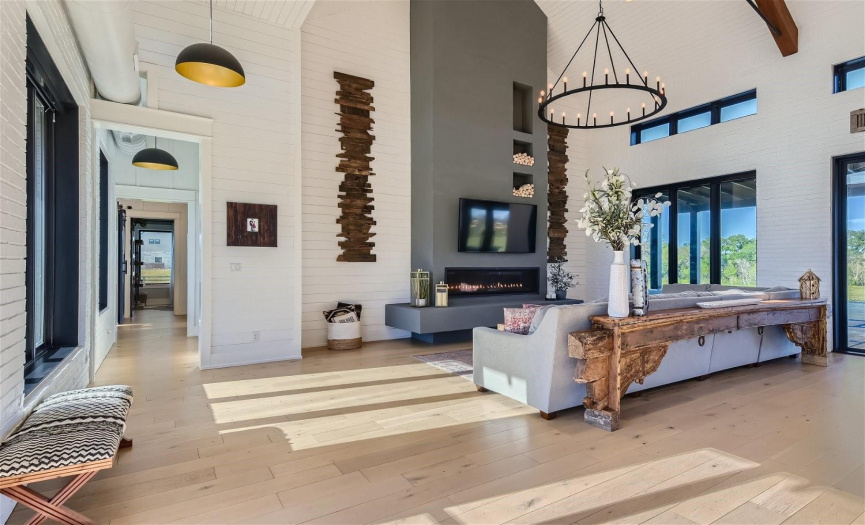 Upon entering, the spacious living area welcomes you with soaring, beamed ceilings, complemented by the rustic charm of painted brick and elegant shiplap walls, creating a warm and inviting atmosphere.