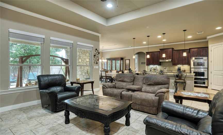 living room, open floor plan, high ceilings, tile floors, large windows, natural light and fireplace