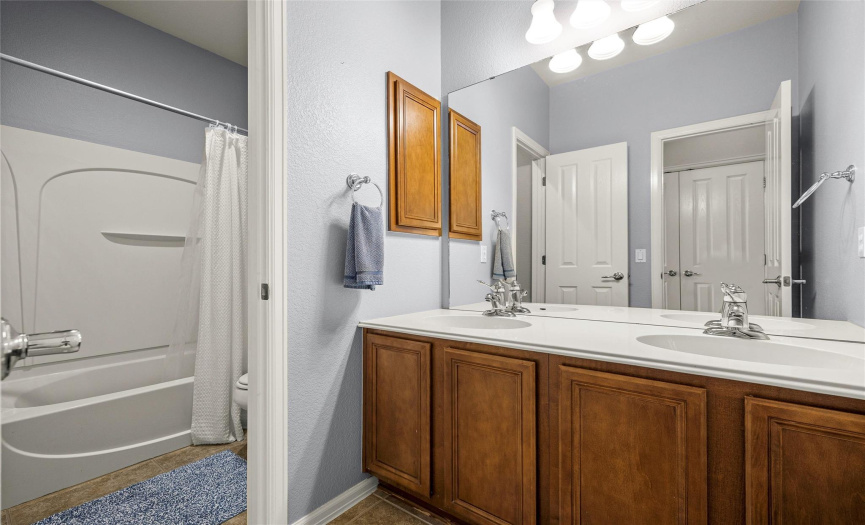 Secondary bath, located in the hallway between the secondary bedrooms, has two sinks for less arguments.