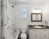This full bathroom includes a framed mirror and a deep soaking tub/shower combo.