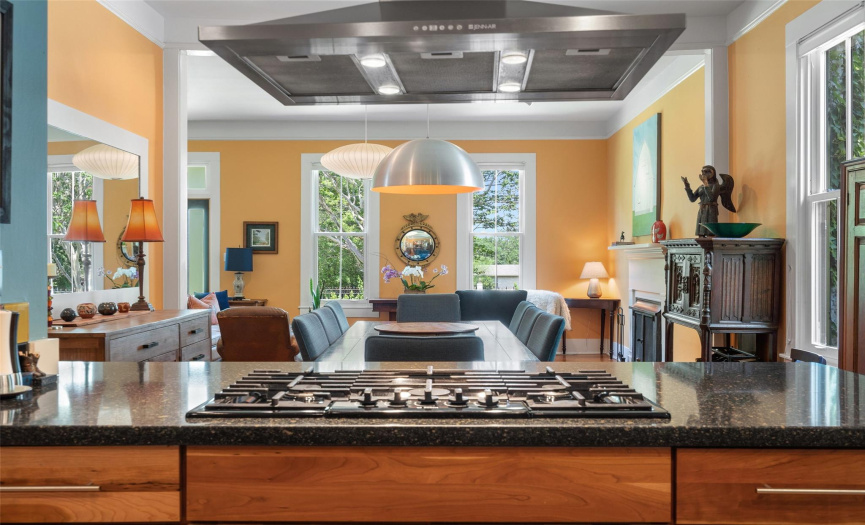 A vented exhaust van, black quartz countertops, and a cooktop that overlooks the dining.