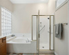 Shower has a seat area and grab bars for safety. 