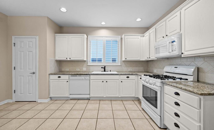 Charming eat in kitchen with newly painted cabinets and granite counters
