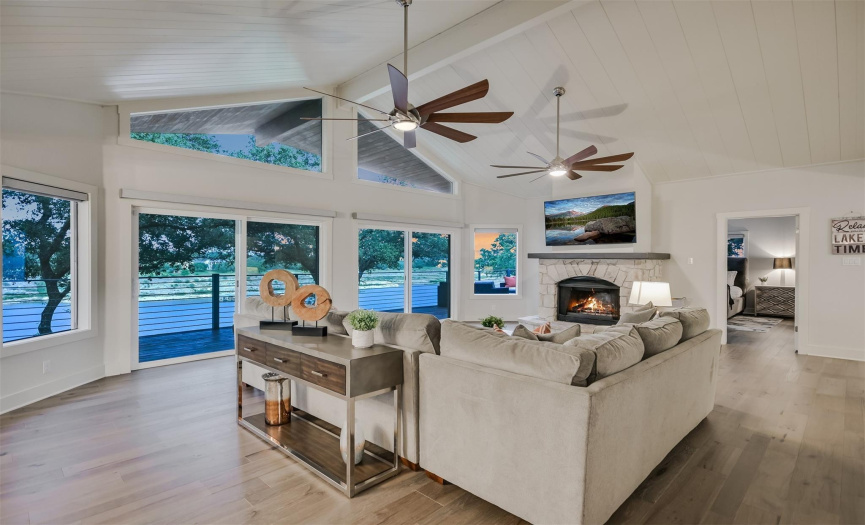 The spacious living room features floor-to-ceiling sliding glass doors, offering uninterrupted views of Lake Travis , direct access to the expansive balcony and filling the space with natural light