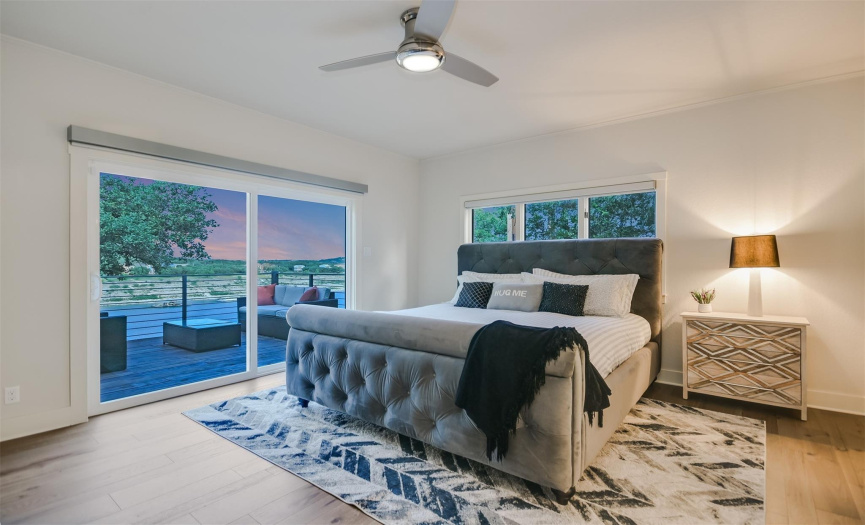 The primary bedroom features a sliding glass door that frames stunning lake views, creating a serene retreat