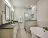 An elegant en-suite bathroom in the primary bedroom boasts a soaking tub and a separate glass-enclosed shower