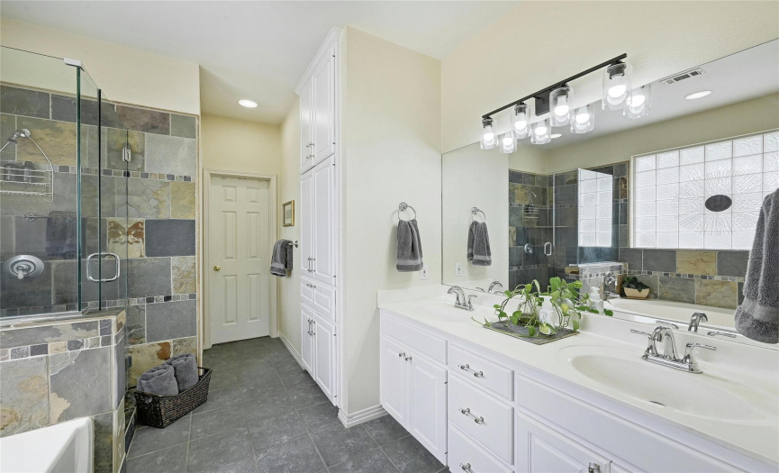 The primary bath suite includes double vanities, oversized shower, garden tub, and a private commode.  You  will love all the extra storage cupboards in this bathroom, and the generous primary closet to the back of the room.