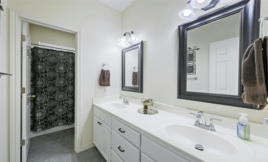 It is so nice to have double vanities in the guest bathroom!  A door leads to the shower/commode room, making this space even more functional!