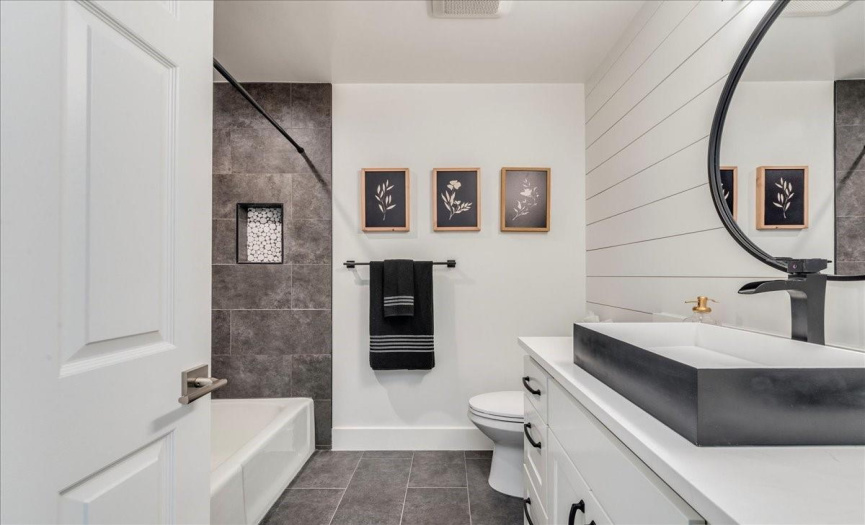 this second bathroom has a modern farmhouse feel with the new wall and custom cabinet and sink