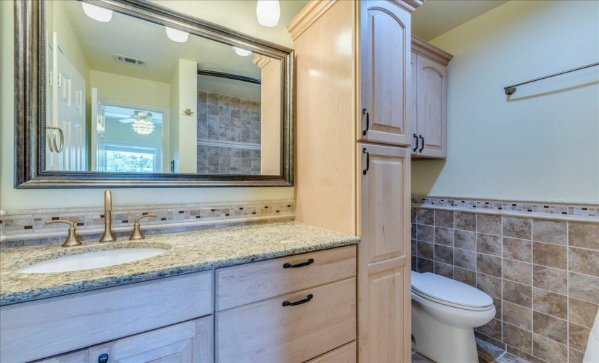 Updated and upgraded! The en suite bath boasts customized natural wood cabinetry with pull-out storage and a granite countertop.