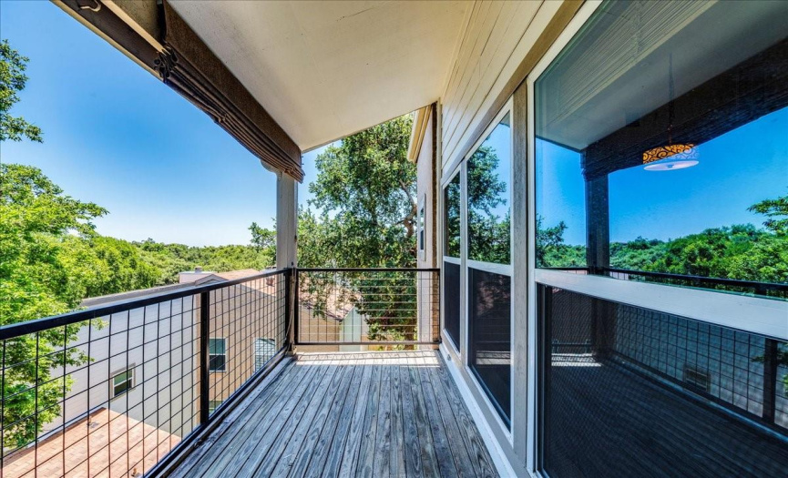 . A glass inset door leads to the covered deck, perfect for enjoying the green views. 