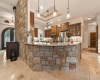 This view of the stonework shows room for bar stools under the granite countertop and drop-down light pendants.