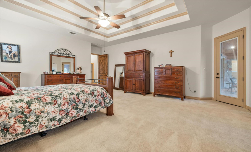 The master's retreat has a very high coffered ceiling with fan and a door to the magnificent covered back patio. The walk-in master closet is extra large with multiple shelves.