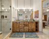 This master bathroom offers more knotty alder hardwood, dual vanities, and drop-down pendant lighting.