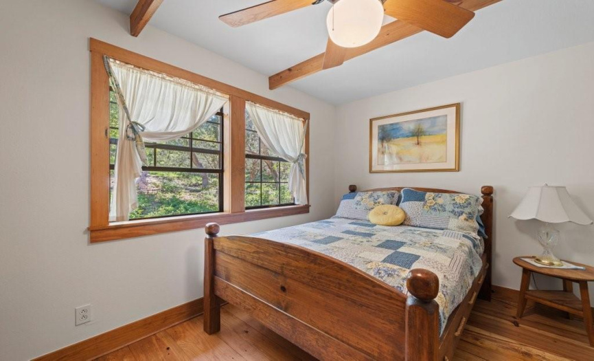 Front bedroom has generous windows overlooking the front garden areas and fountains along with Pine floors.